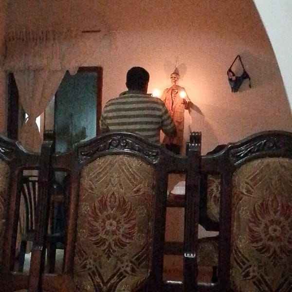 Person poses with decorated skeleton figure in Tinaquillo