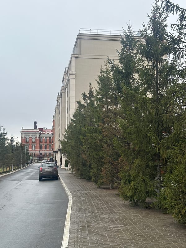 Vehicle travels wet street in Kazan during rainy conditions