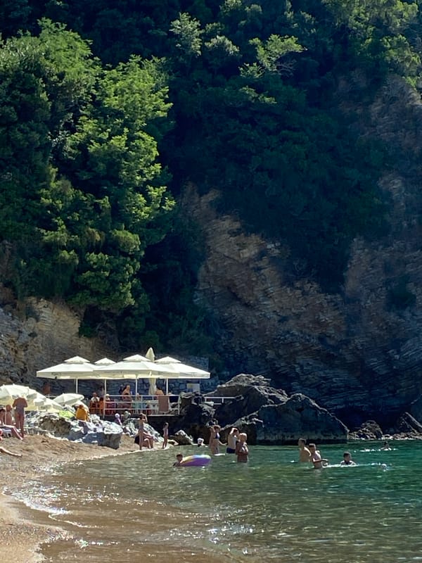 Sunny morning on Budva's beach, coastline and rentals in view