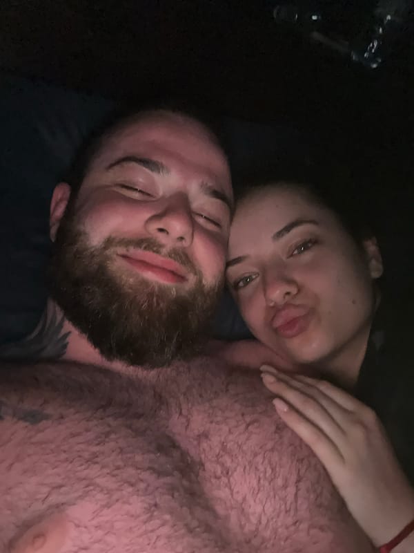 Intimate moment captured between man and woman in dimly lit setting