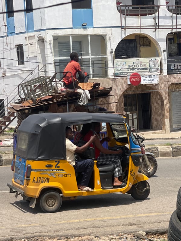 Street life on a busy urban road: rickshaws, carts, and pedestrians