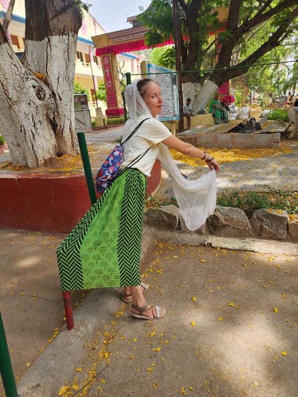 Woman in patterned green skirt observed outdoors holding object