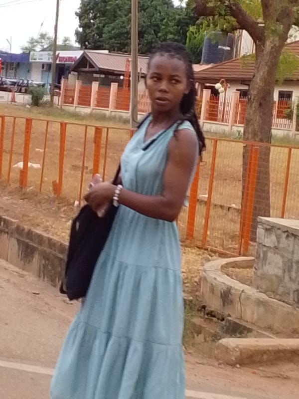 Woman in blue dress stands on Tamale street