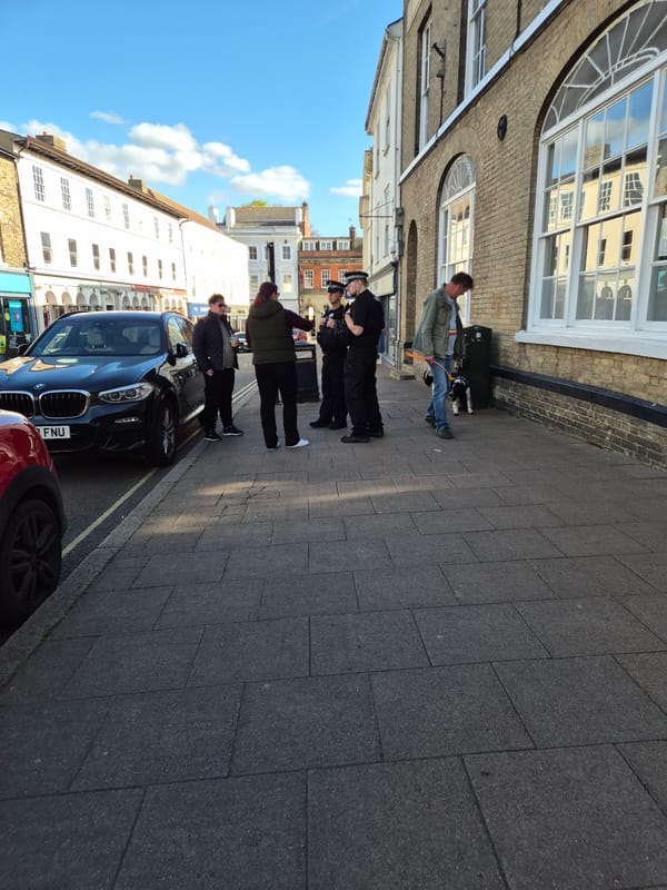 Pedestrians gather on West Suffolk street Friday afternoon