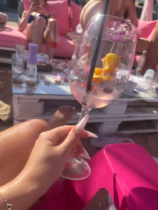 Pink cocktails and party favors at a beachside celebration