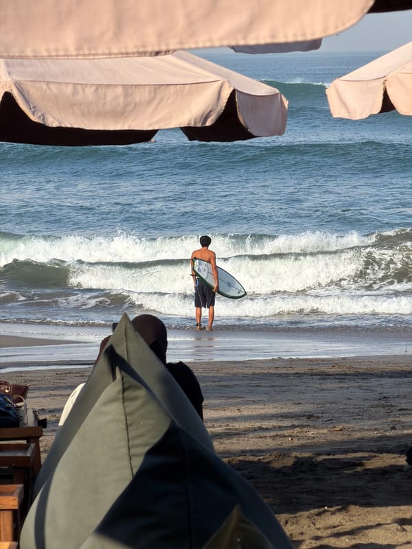 Surfers, beachgoers, and café life on a North Kuta morning