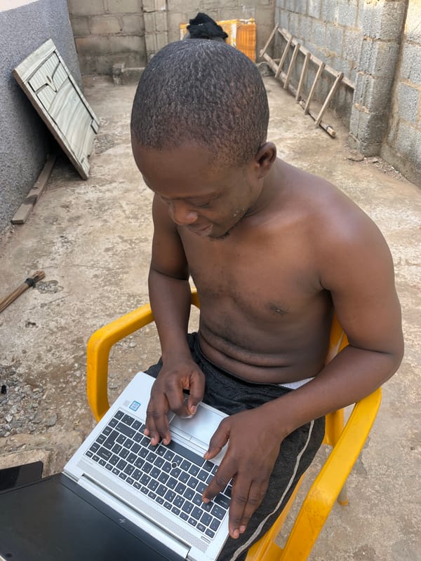 Man works on laptop outdoors in Abuja construction area
