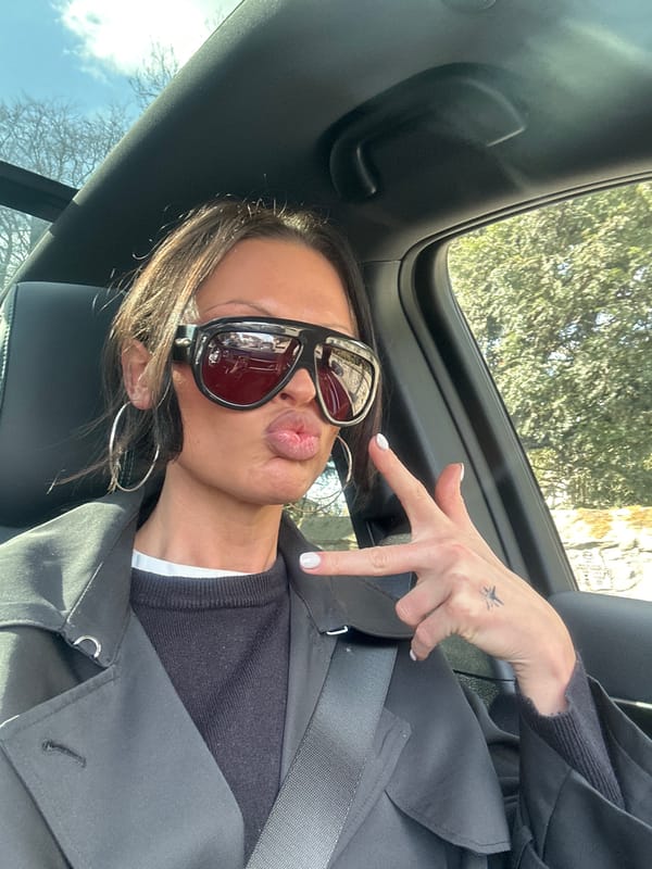 Woman in sunglasses and jewelry observed in vehicle