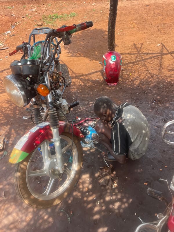 Daily life documented in Apunu: motorcycle repair, market activity