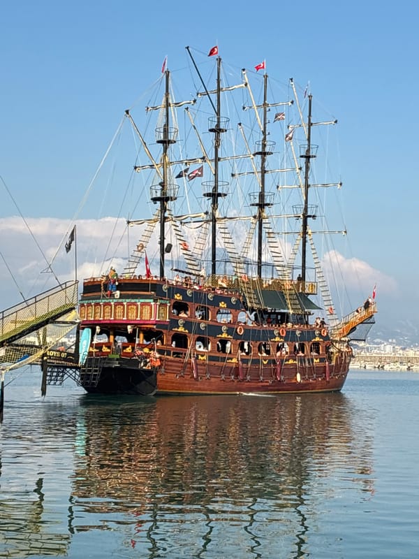 Pirate ships dock at Alanya Marina during sunny afternoon