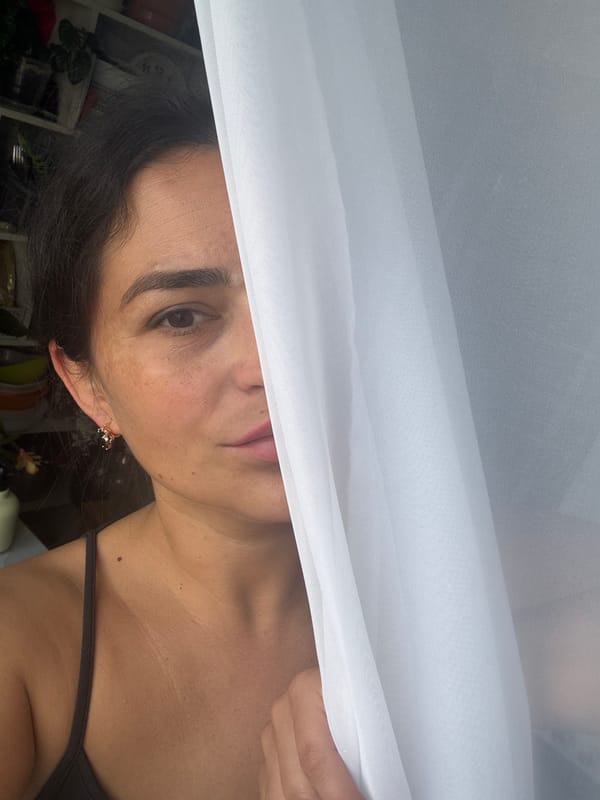 Woman hangs white curtains in Russian home