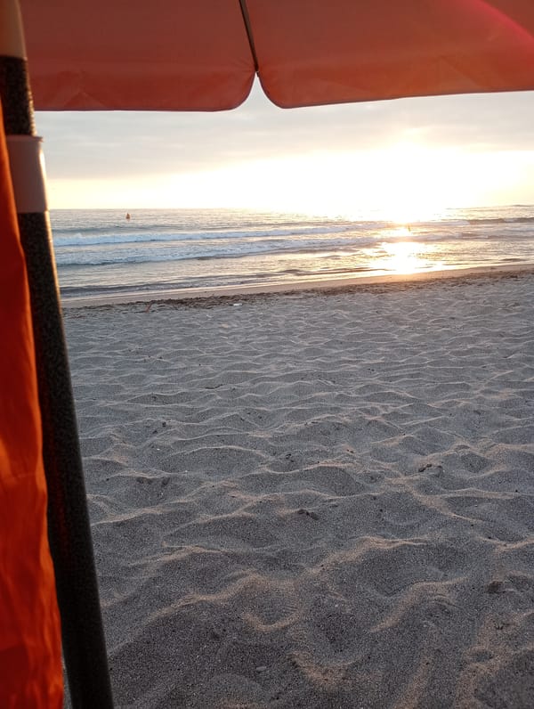 Man enjoys sunset at Iquique beach under city skyline