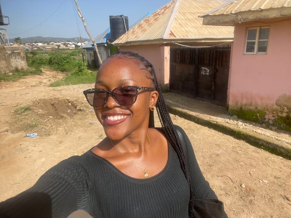 Outdoor selfie session in Jos, Nigeria, with a sandal repair nearby