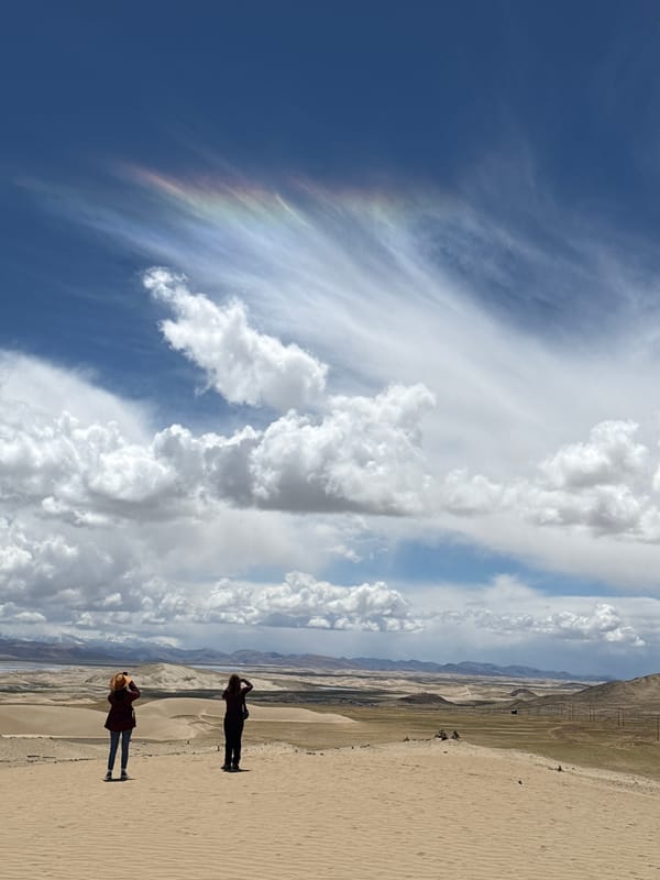 Rainbow clouds appear over Labrang township desert landscape
