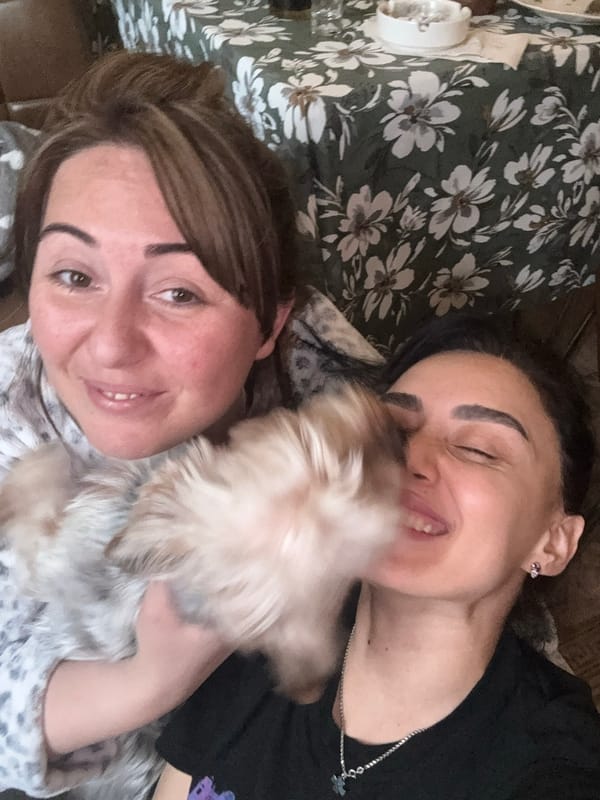 Two women share afternoon drinks with dog in Tbilisi home