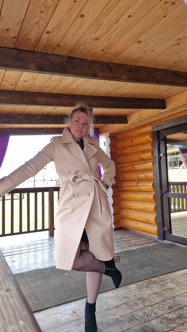 Woman poses for photos in beige coat in Otchor, Russia