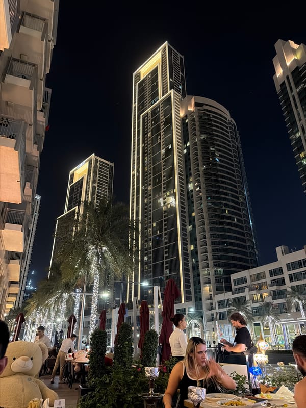 Downtown Dubai nighttime scene captured with illuminated buildings, pedestrians