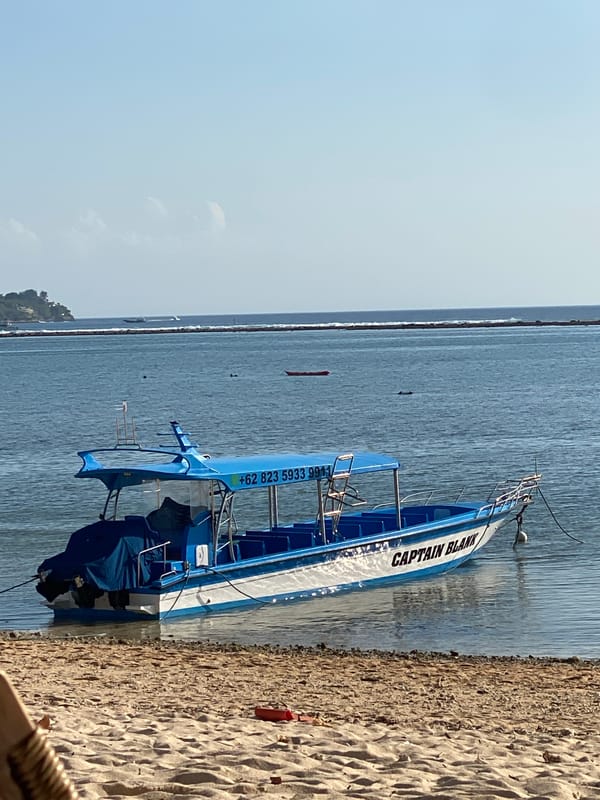 Quiet morning at a Nusa Penida beach with boats and shoreline scenes