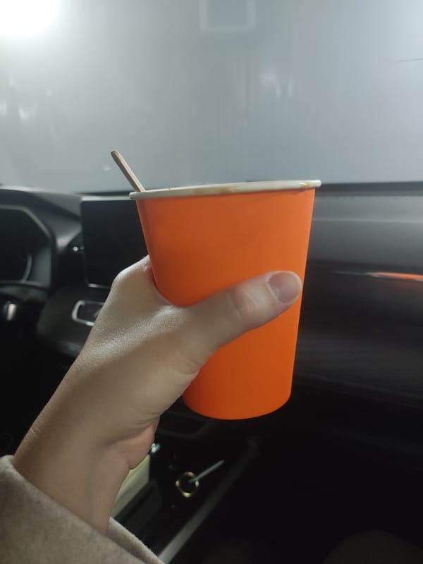 Driver enjoys beverage during sunset commute through snowy Votkinsk