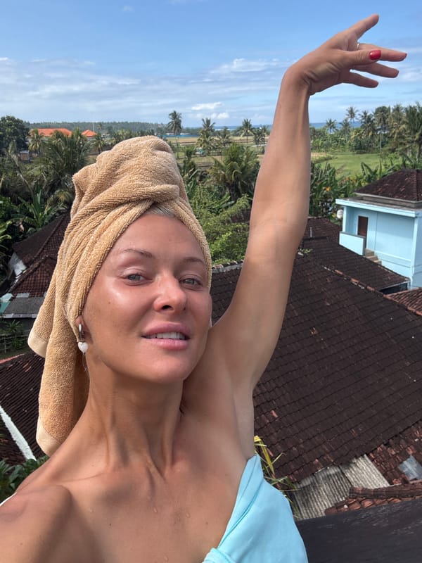 Woman takes selfie, waxes surfboard during early morning outdoor session