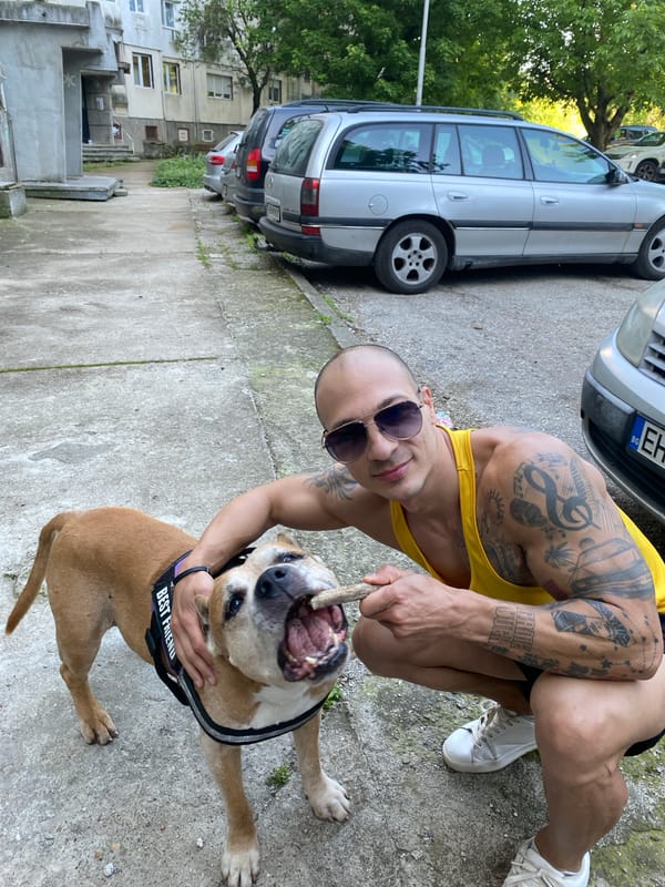 Tattooed man plays with dog in Pleven, Bulgaria