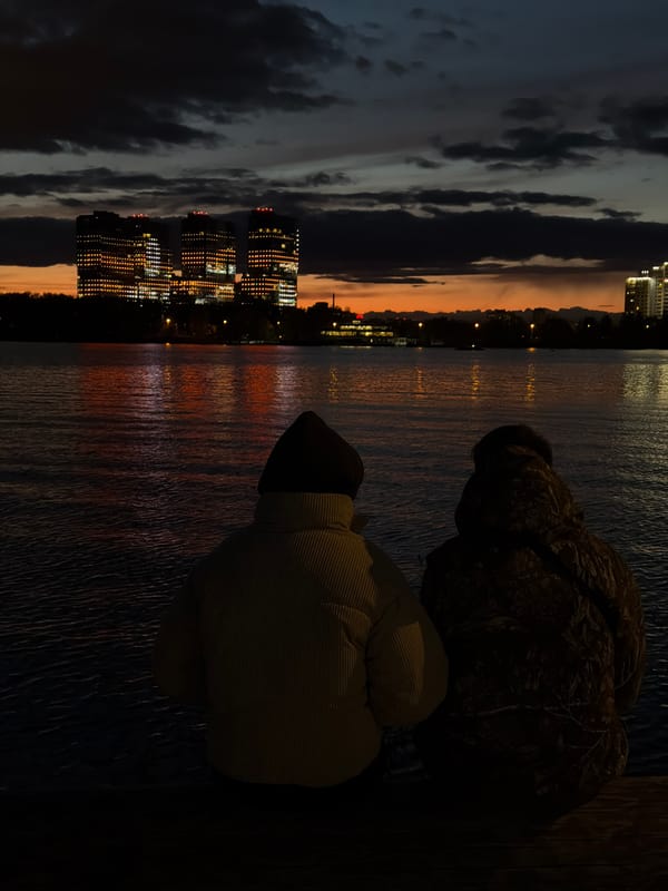 Evening riverside gathering captured in illuminated Kazan cityscape