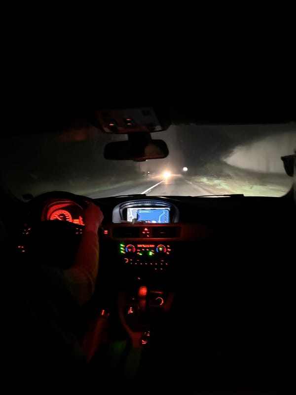 Vehicle travels nighttime road in Dyuni, Bulgaria