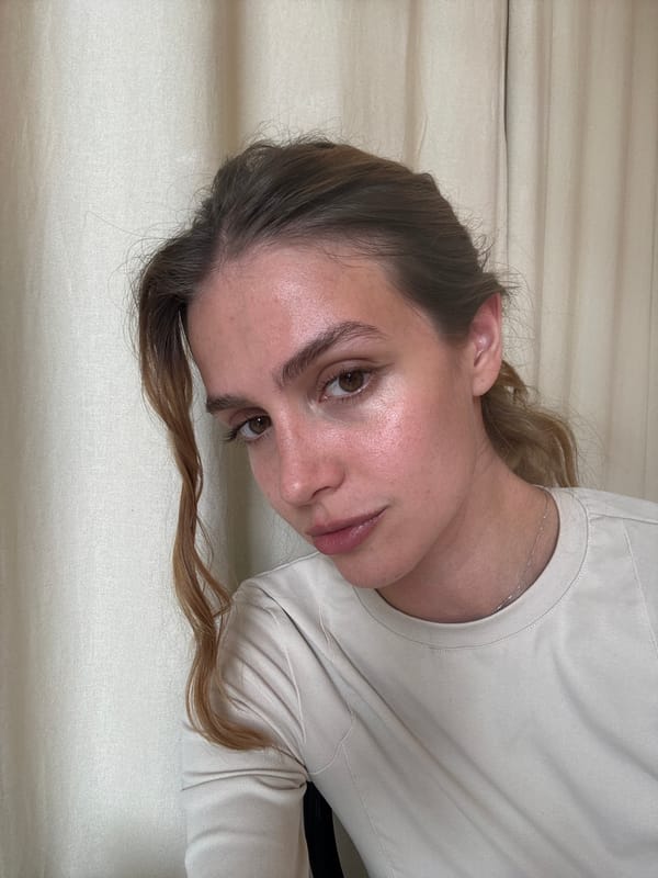 Woman in beige shirt observed in close-up portrait