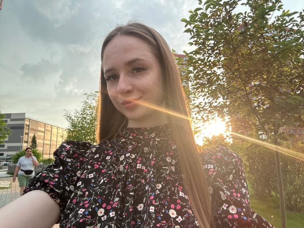 Woman documents afternoon through selfies in black floral dress