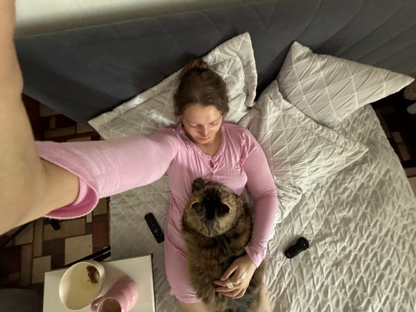 Woman relaxes with tabby cat on bed in Izhevsk