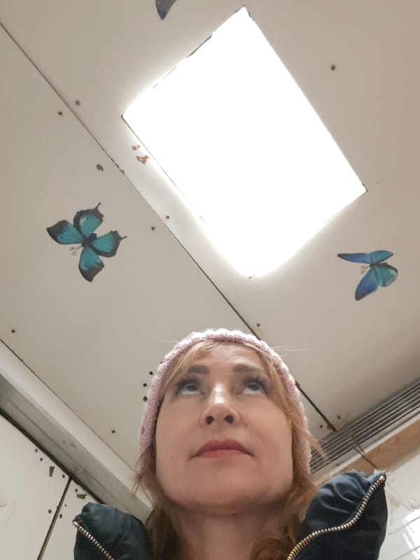 Woman in pink hat gazes up at skylight