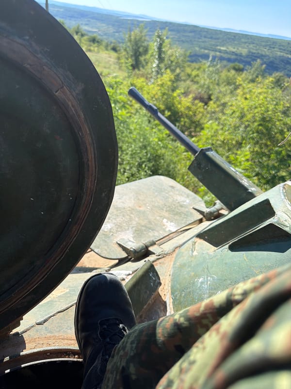 Tank and white smoke on hilly terrain in rural Bulgaria