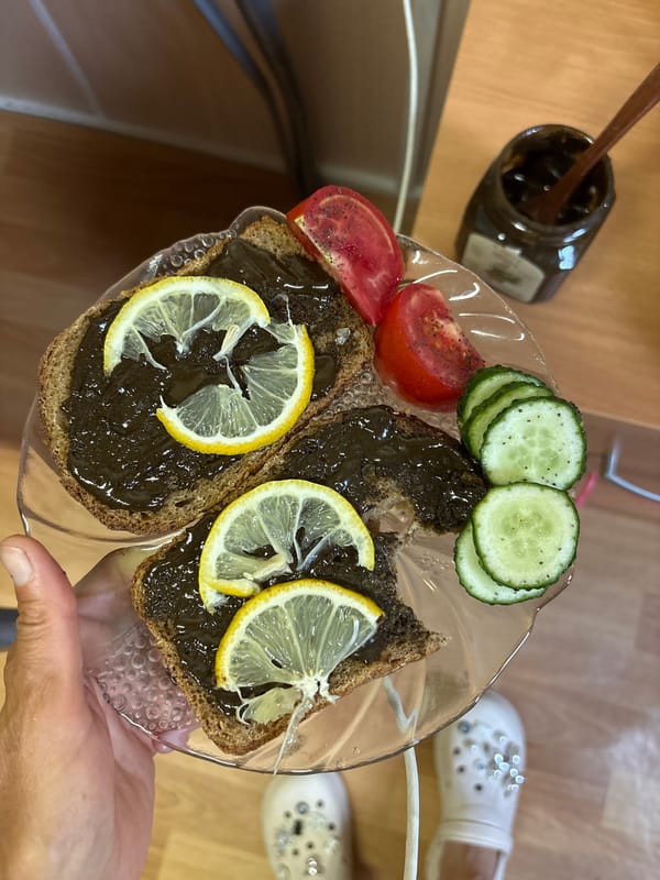 Dark bread with paste and fresh vegetables on a plate