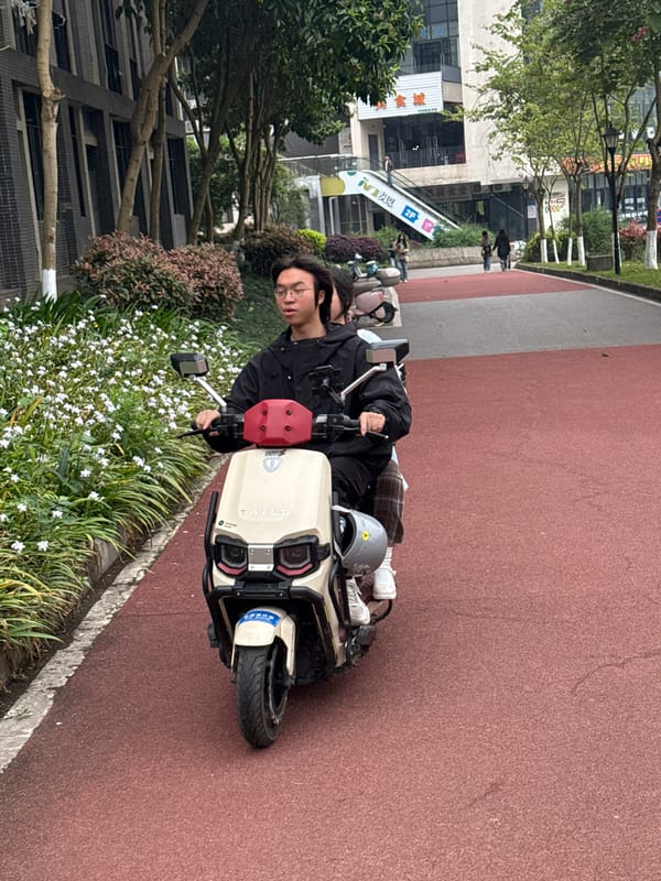 Electric scooter rider pauses on red path in Jiangjin