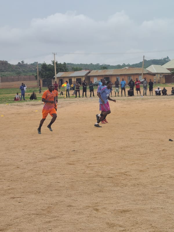 Casual soccer match draws players and spectators to dirt field
