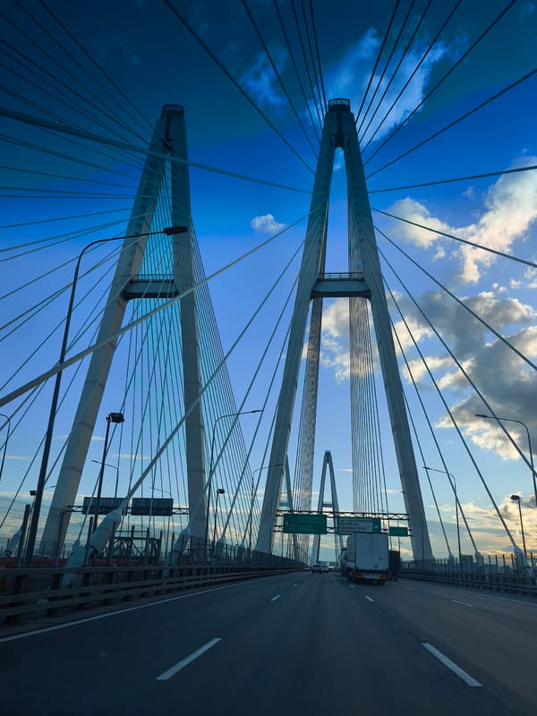 Vehicle crosses cable-stayed bridge on clear afternoon