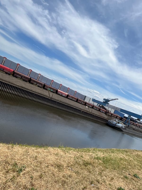 Freight train docked at Neuss industrial port alongside a canal