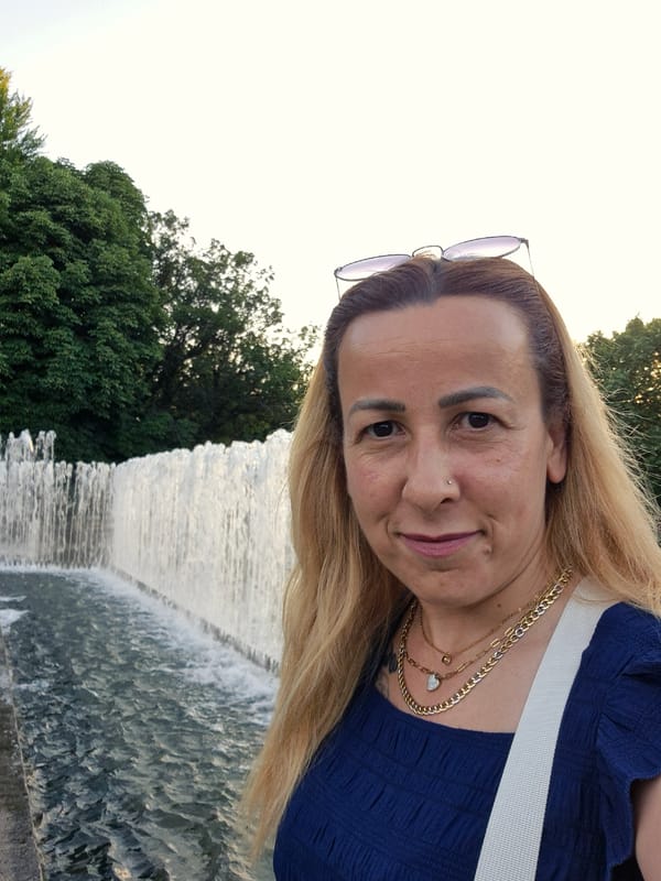 Woman documents evening fountain visit with selfies and illuminated displays