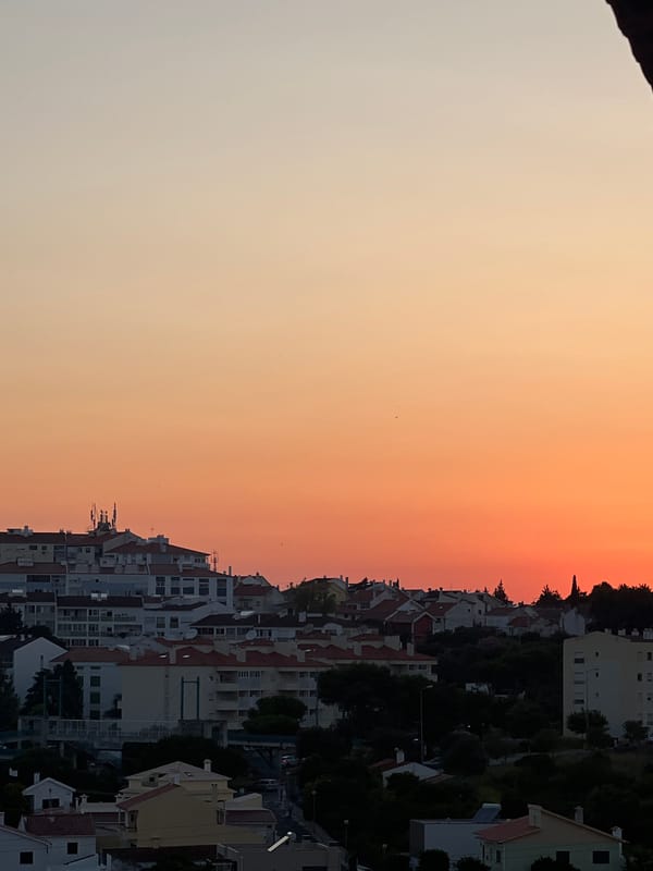 Cascais rooftops glow under a vivid summer sunset