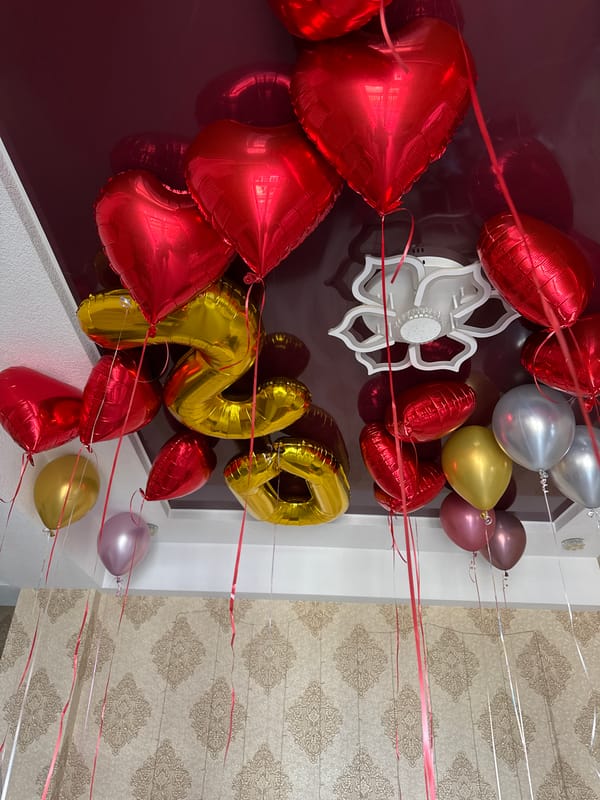 Balloons and red roses mark a festive celebration setup