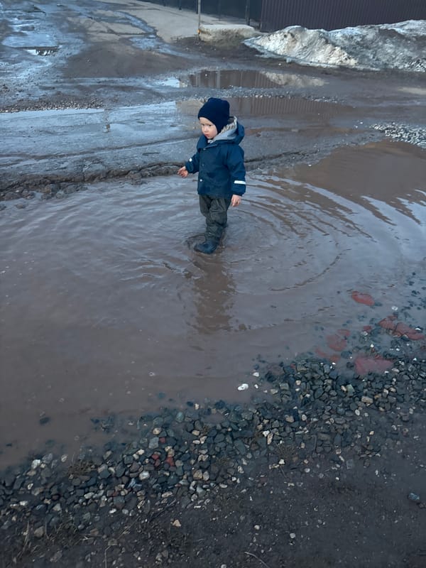 Child plays in flood puddles on damaged roads in Russia