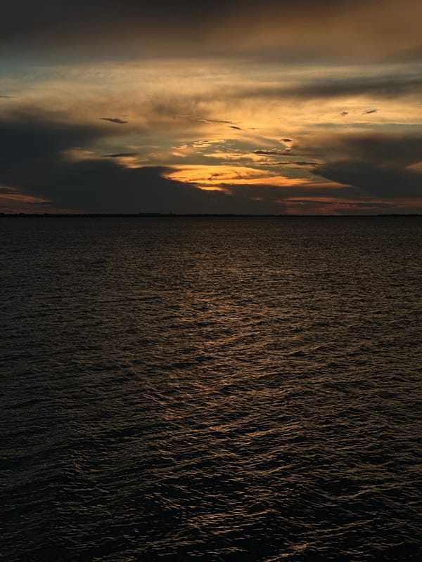 Dramatic sunset captured over Kokshetau waters with boats present