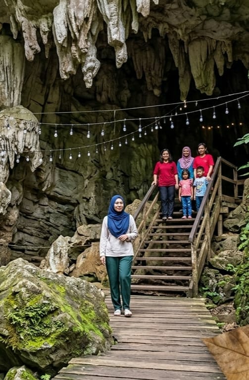 Inside a lit cave grotto with turquoise pools and waterfalls