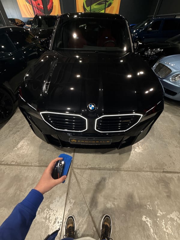 Person with car key approaches BMW in Plovdiv garage