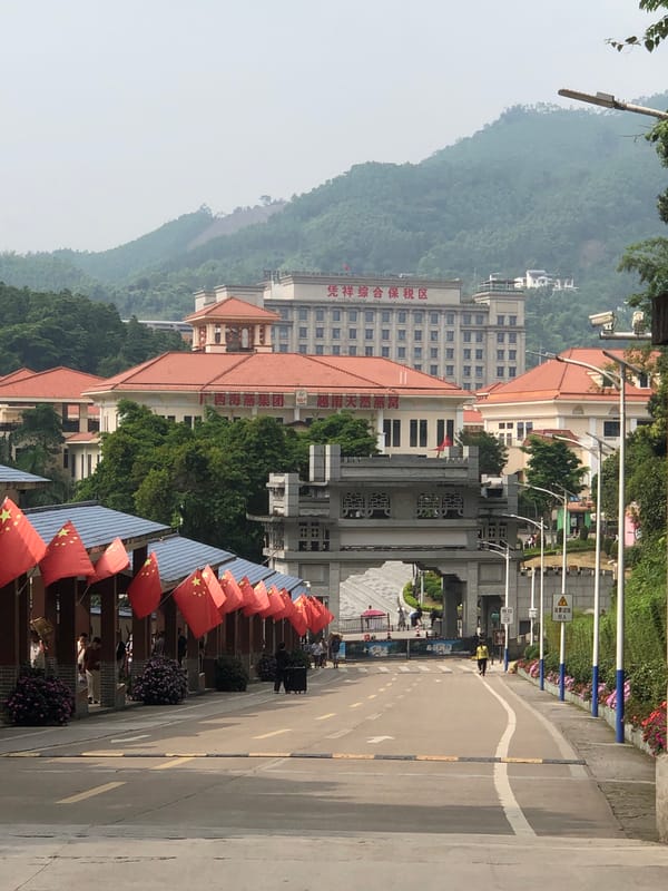 Morning pedestrians with luggage walk past flag displays in Quli
