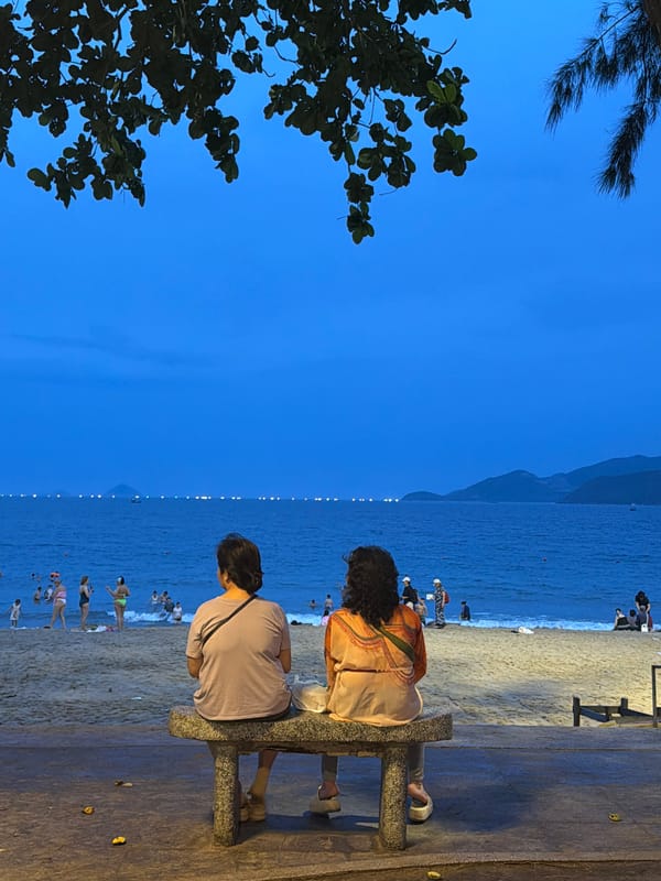 Nha Trang beachfront at dusk, people watching the ocean