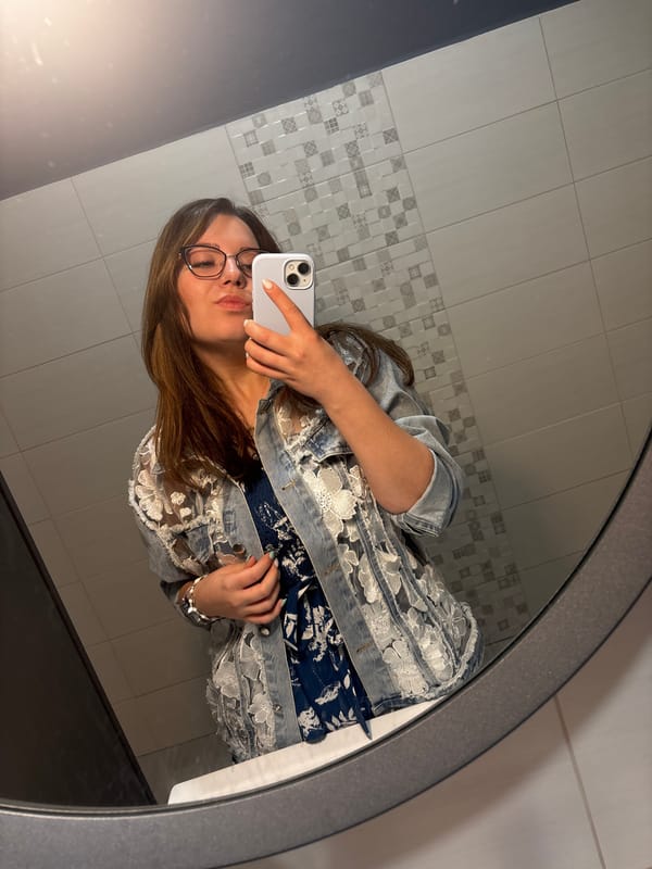 Bathroom mirror selfie in floral dress and denim jacket