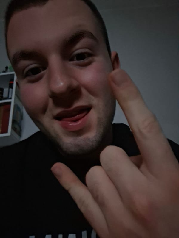 Person makes rock gesture in poorly lit photo