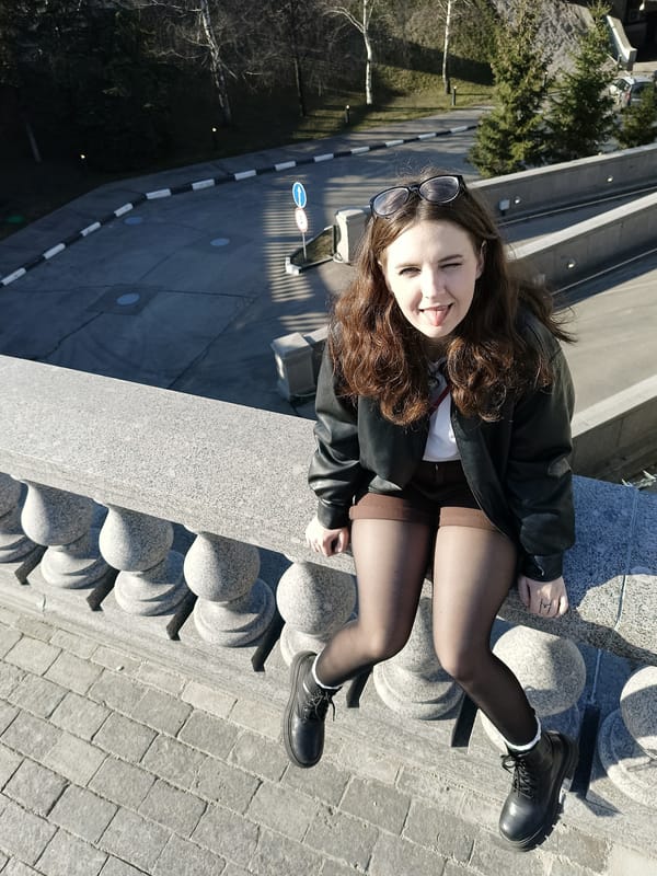Woman poses playfully on stone balustrade in Moscow