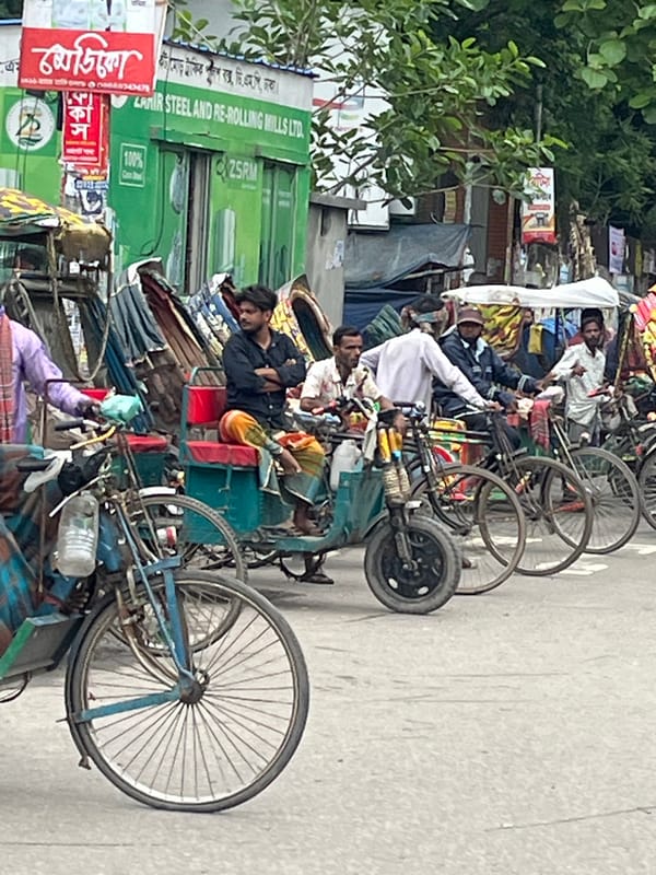 Rickshaw pullers gather on busy Dhaka street